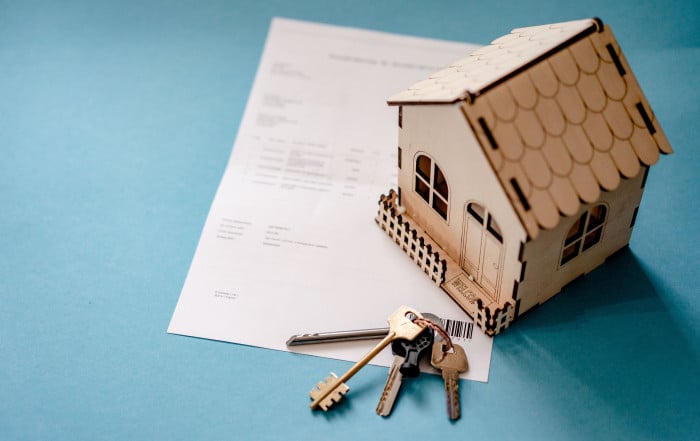 Property title and the simple informative note. House model and keys with contract.